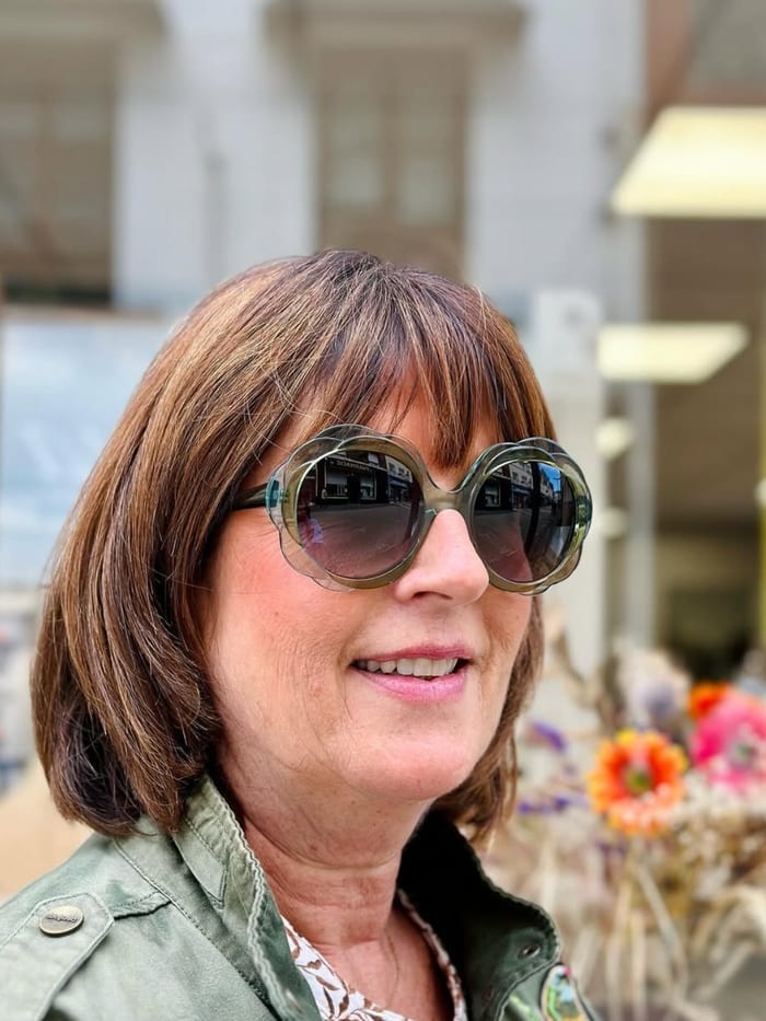 Cliente portant des lunettes de soleil rondes vertes devant la boutique — Gravelines Optique, Montivilliers