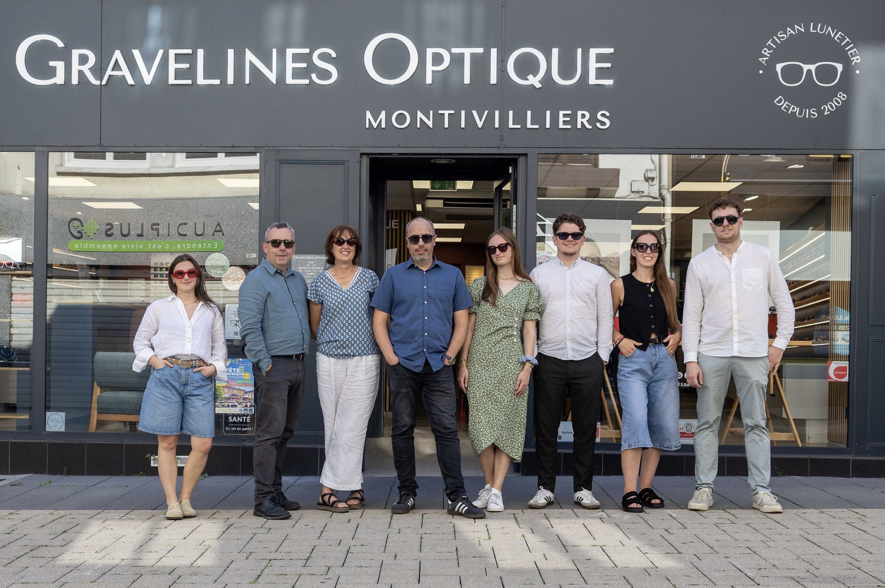 L’équipe de Gravelines Optique au complet, en solaires, devant la devanture du magasin à Montivilliers