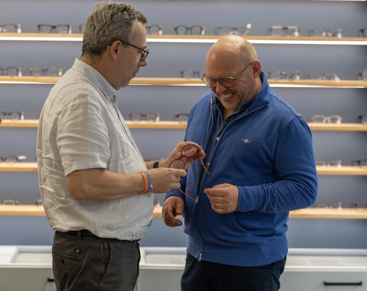 Une opticienne de Gravelines Optique en conseil avec une cliente, au comptoir de la boutique